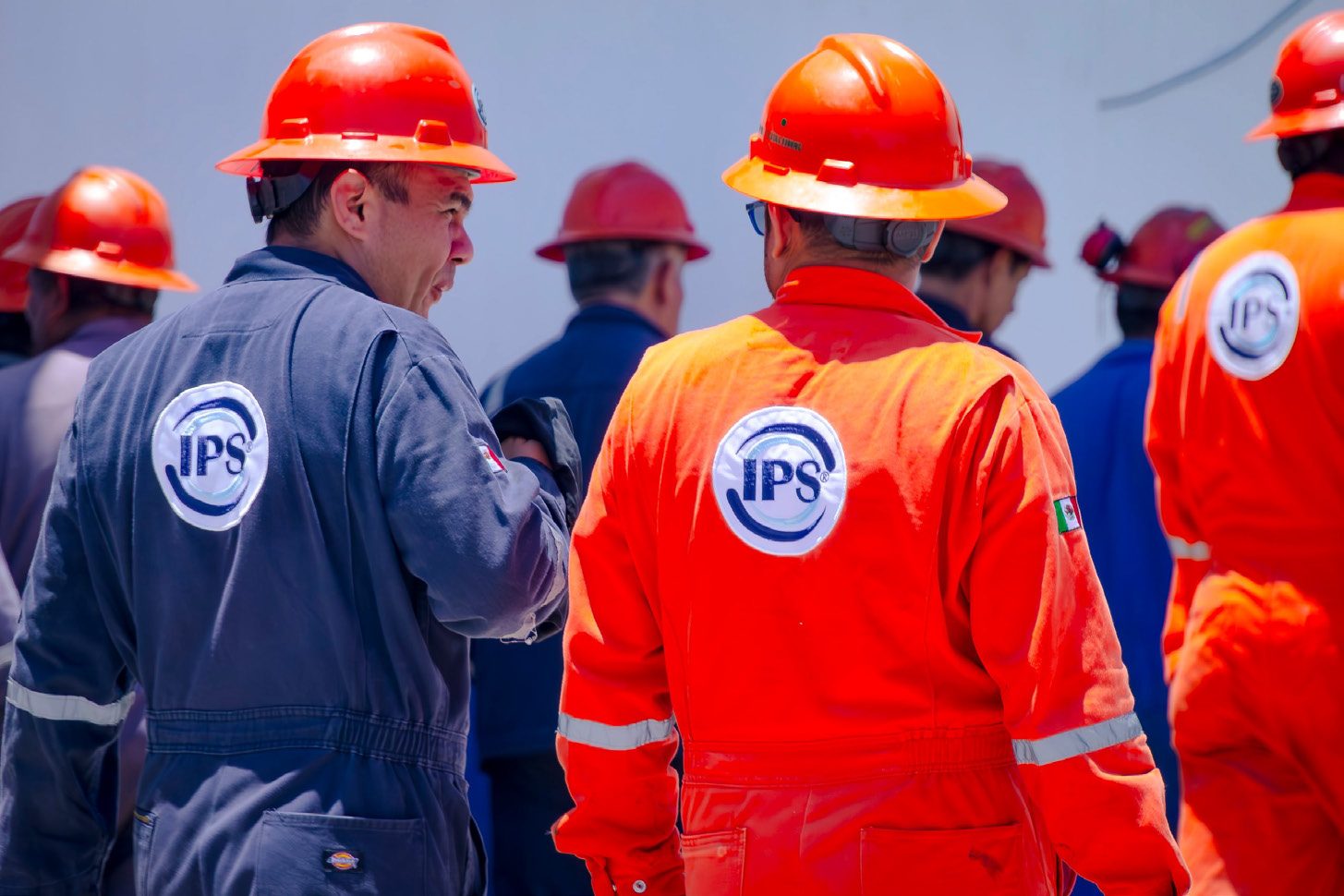 Grupo IPS field crew in hard hats and coveralls