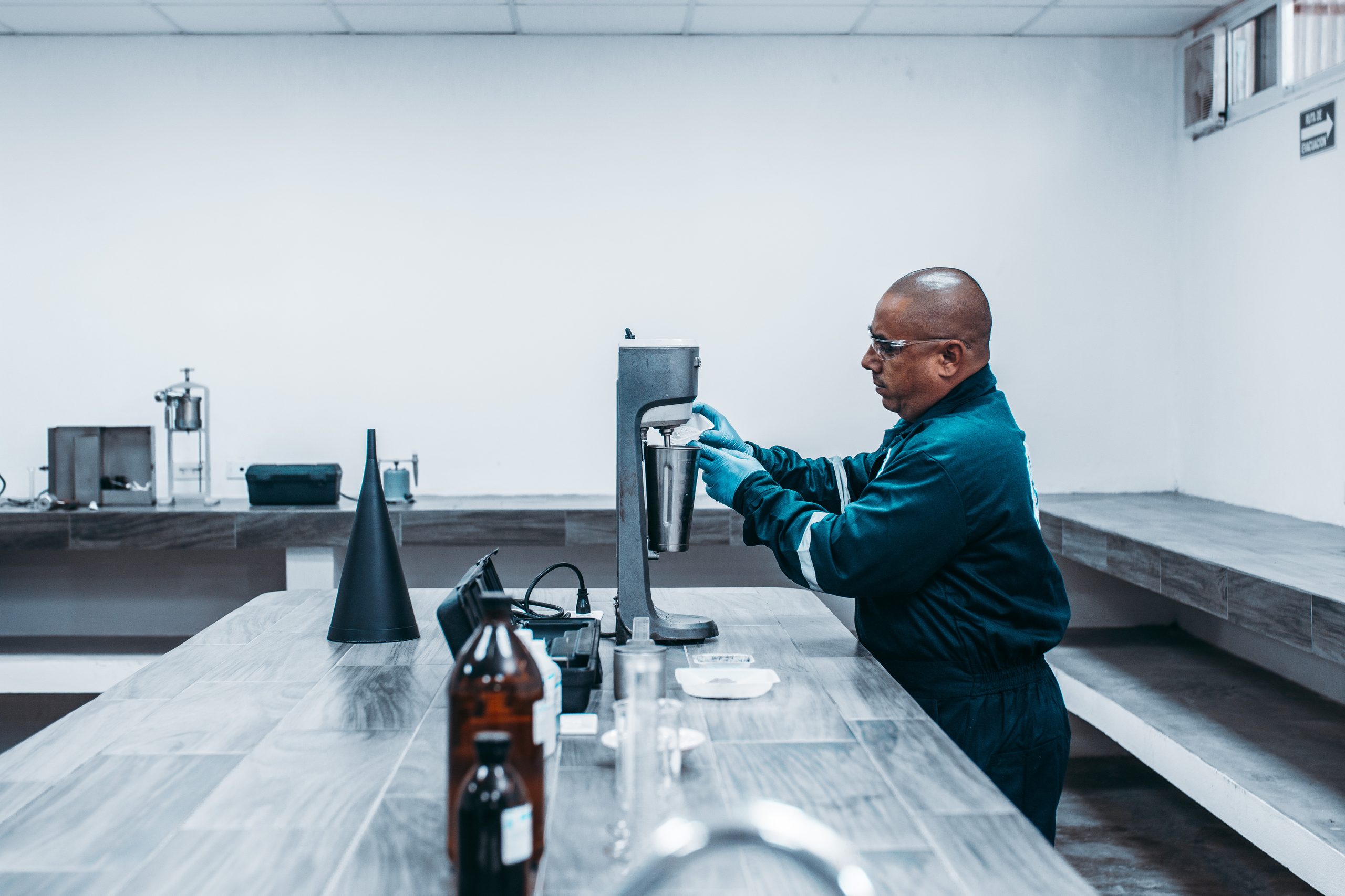 Laboratory technician in safety glasses and gloves preparing a fluid sample