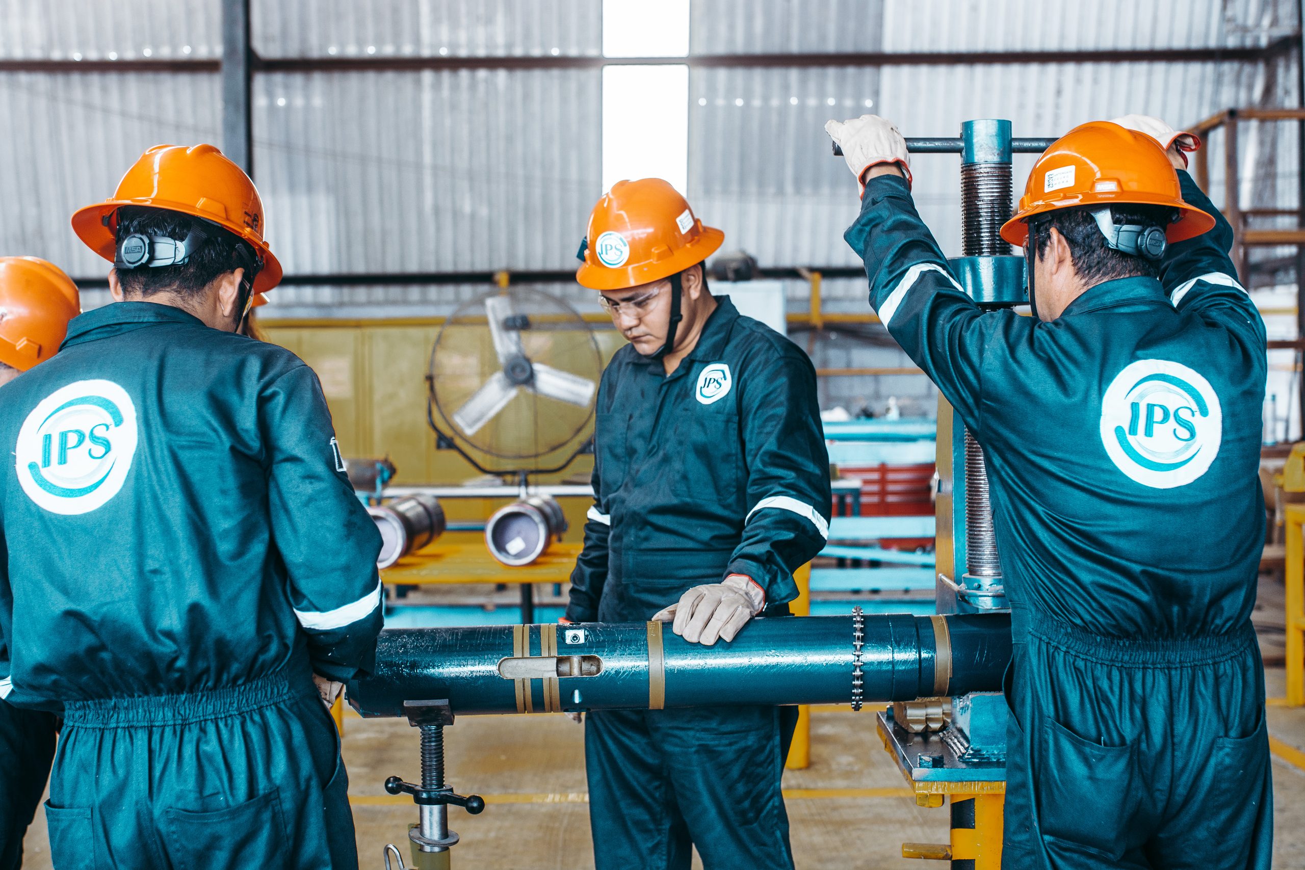 Two technicians assembling a downhole tool in the workshop
