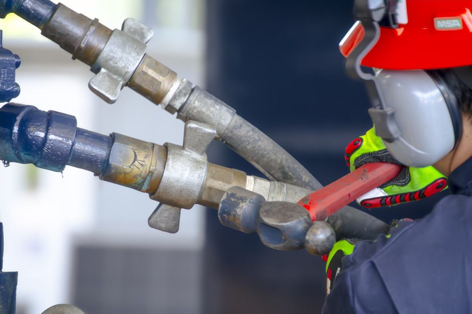 Technician tightening a hydraulic connection
