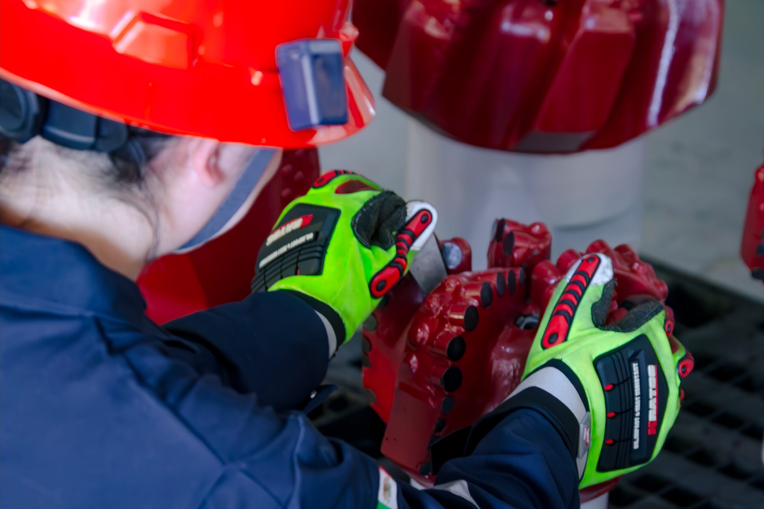 Hands inspecting an insert tricone bit