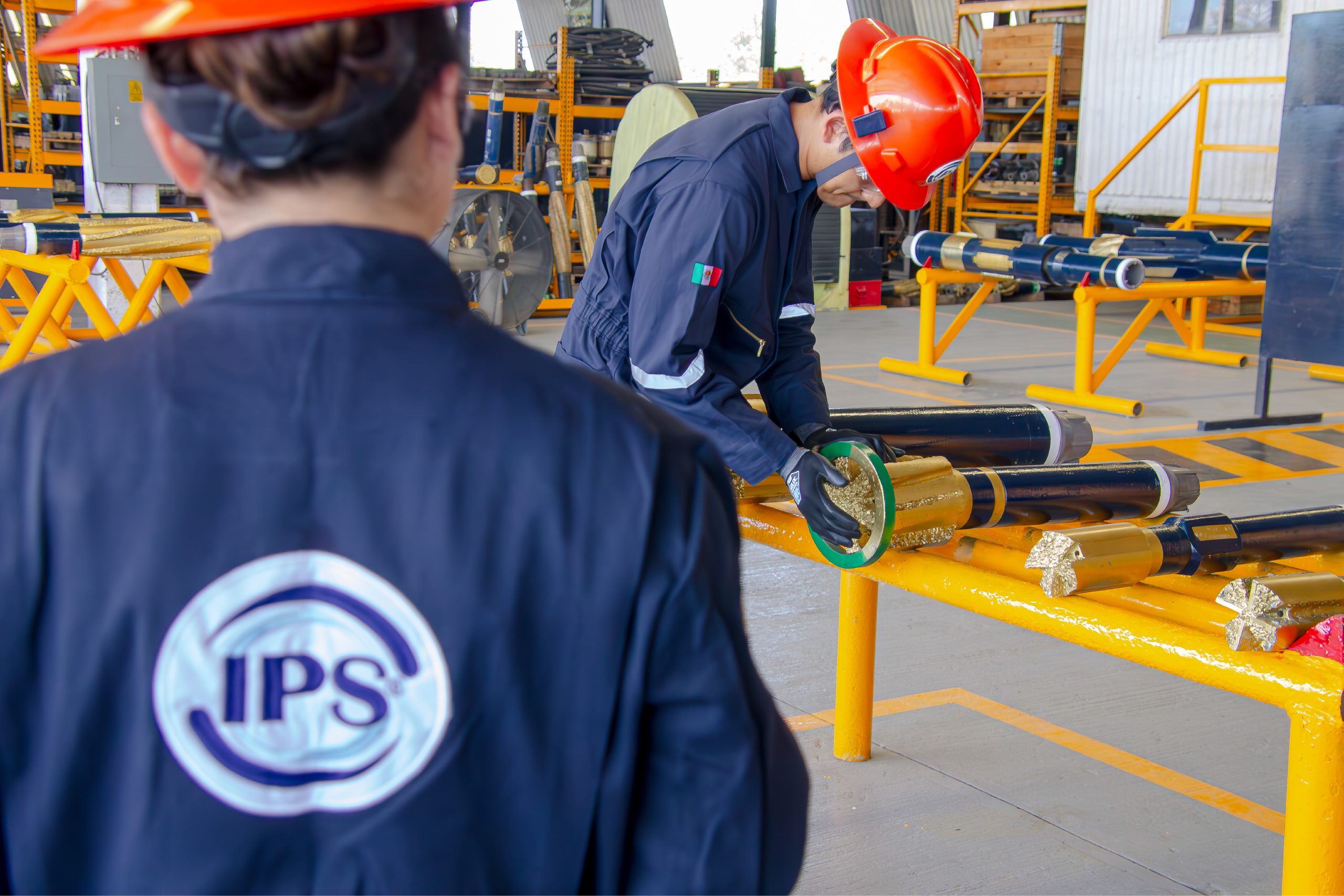 Technician inspecting downhole tools on a workshop rack