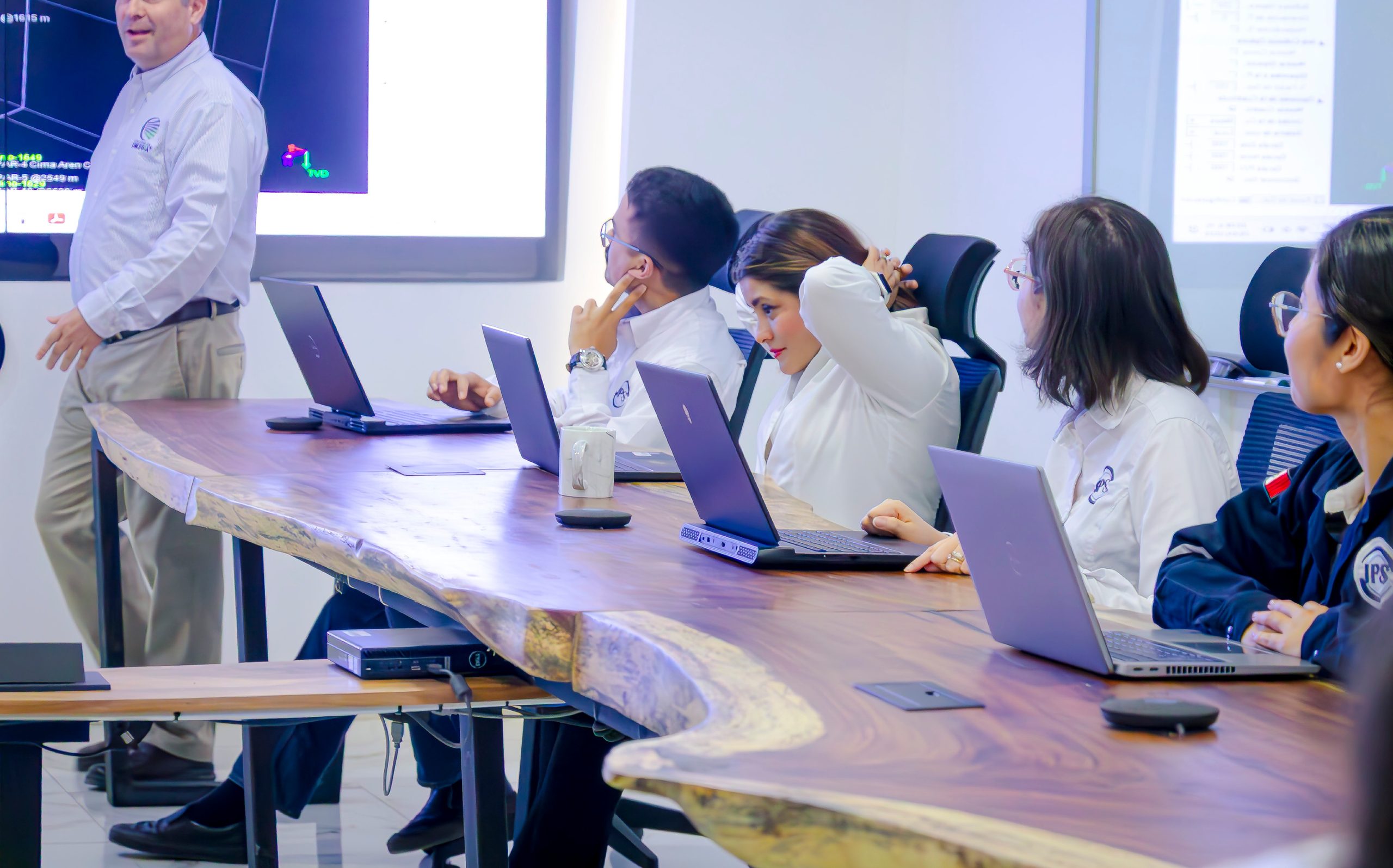 Engineering team reviewing a project on laptops in a meeting room
