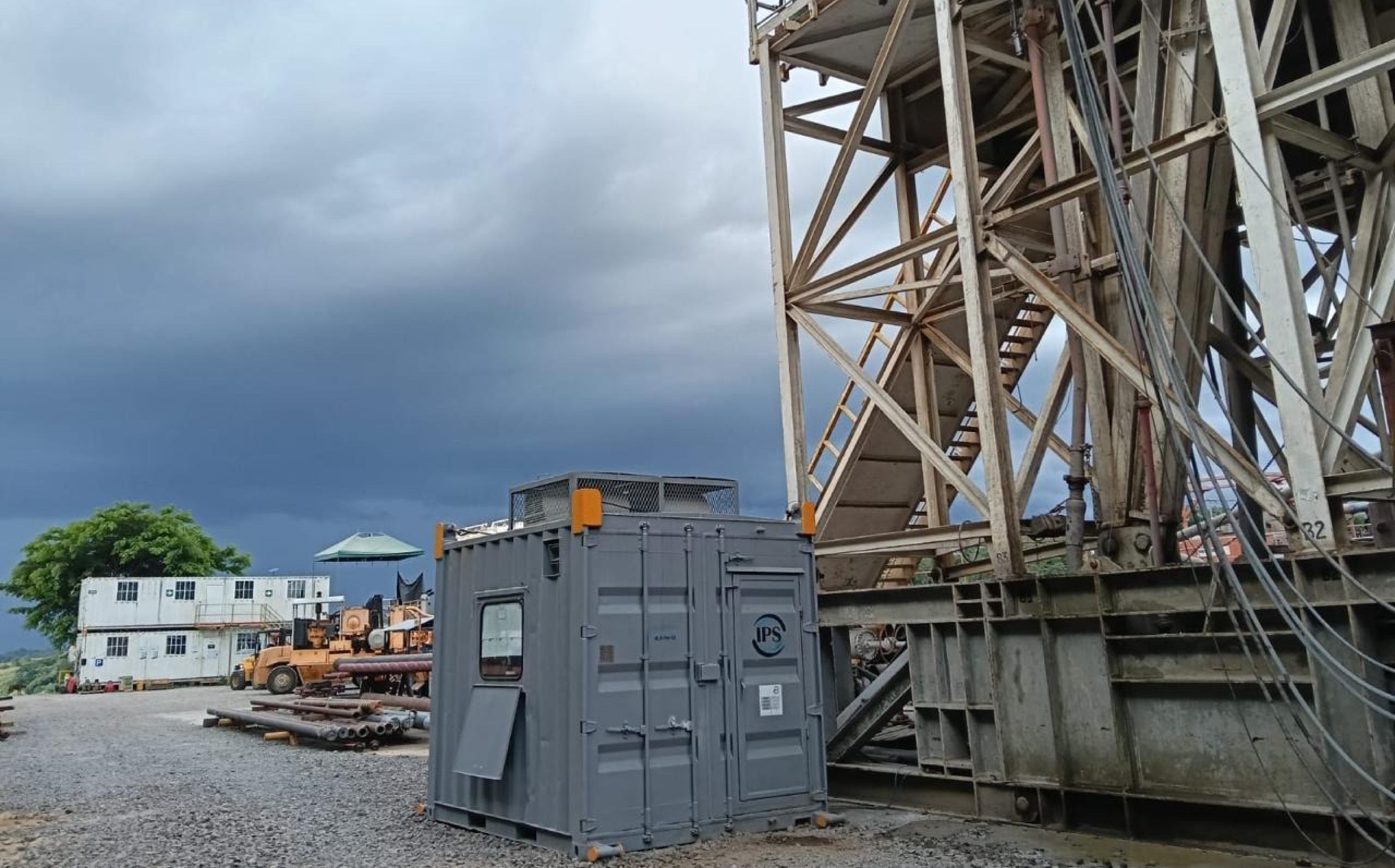 Drilling rig mast and stairways above equipment containers