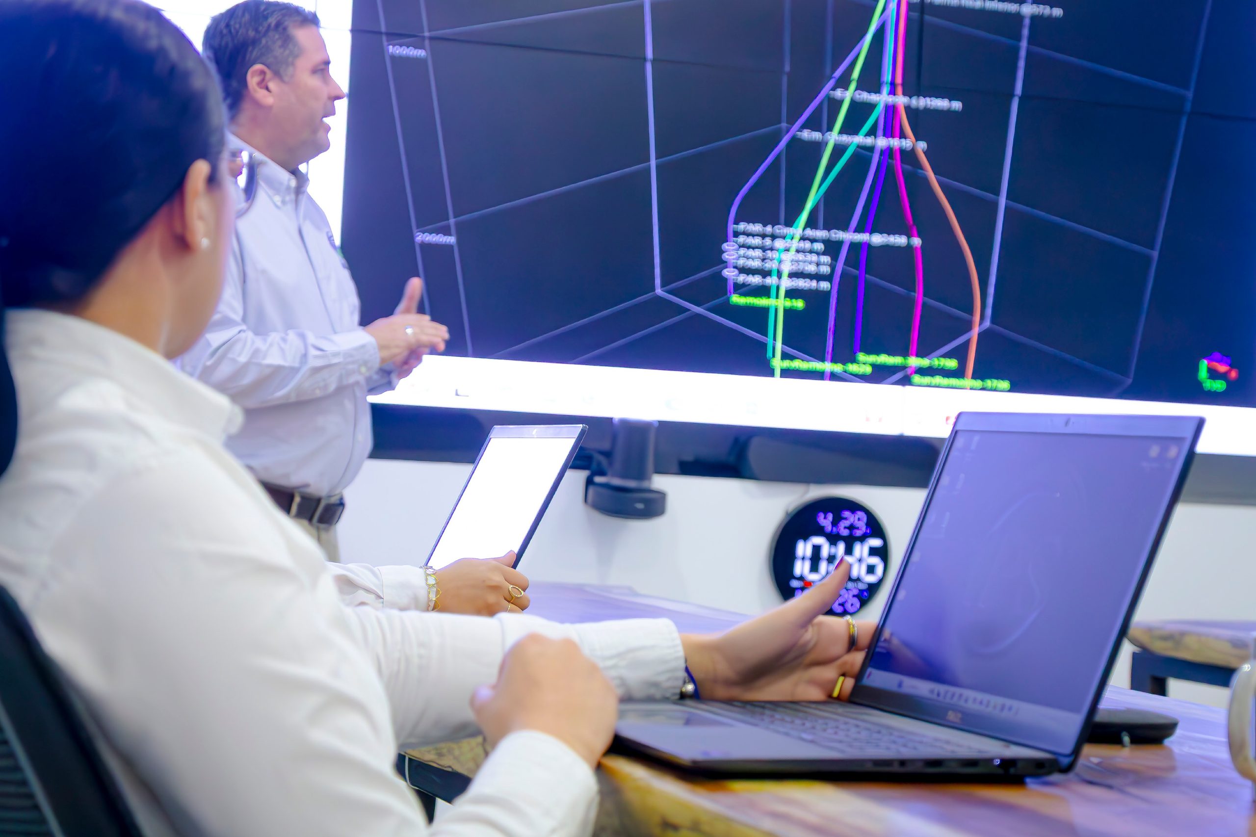 Well trajectory model displayed on a screen above engineering workstations