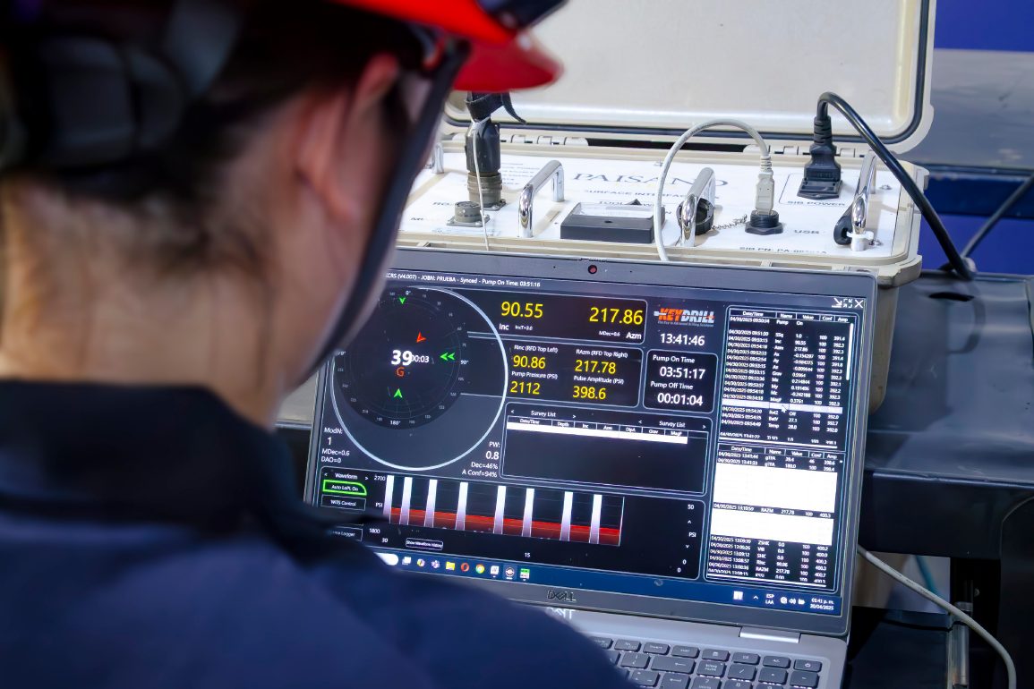 Technician monitoring real-time well test data on an acquisition unit