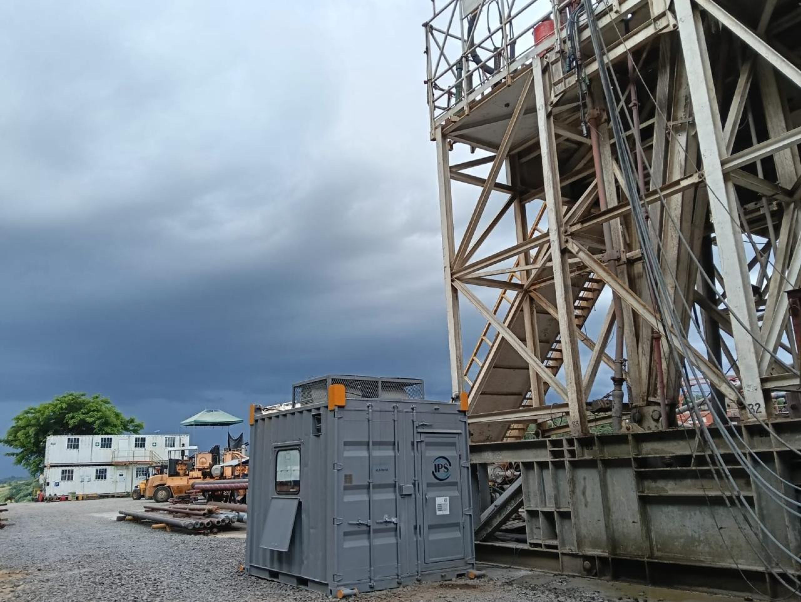 Drilling rig structure above a facility under an overcast sky