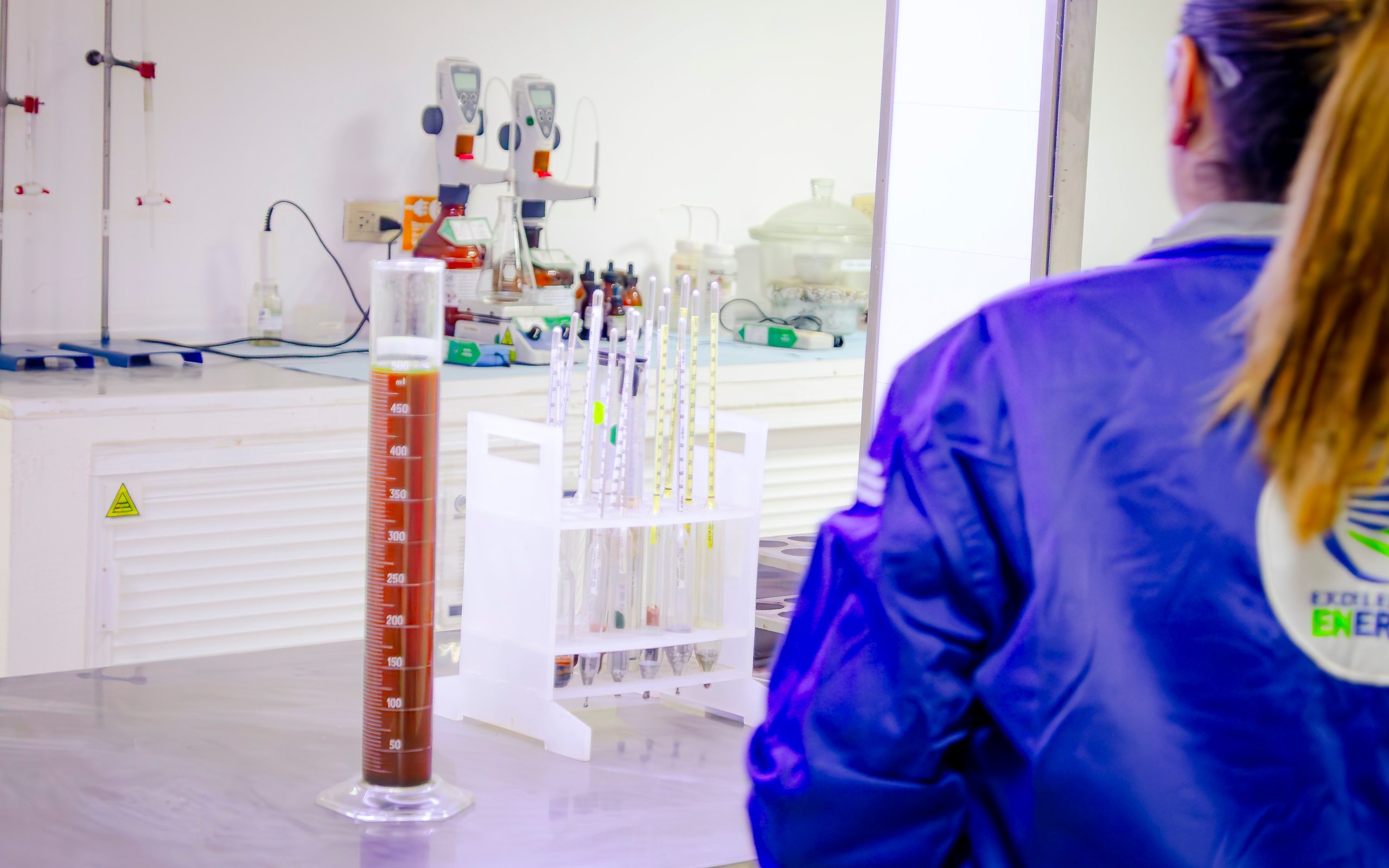 Laboratory technician in a blue coat working at the bench