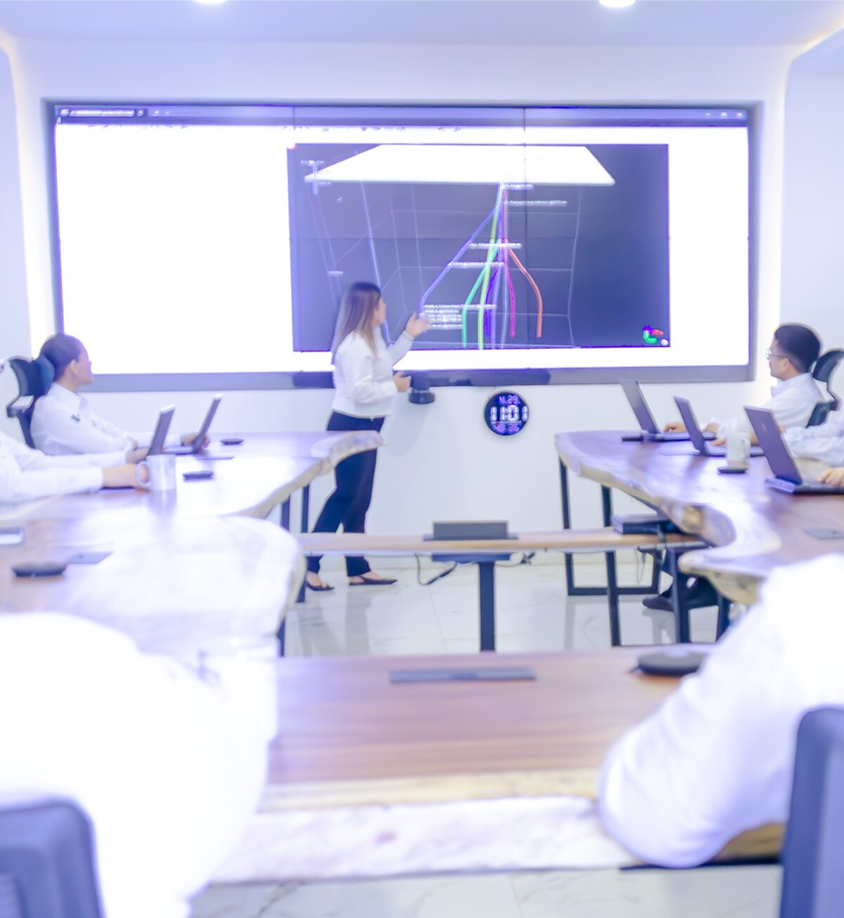 Engineers reviewing well data on a large screen